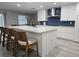 Contemporary kitchen showcasing white cabinets, a sizable island, and blue tile backsplash at 975 Coronado Dr, Punta Gorda, FL 33950