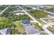 An aerial view of a modern single-Gathering home showcasing its well-maintained lawn and surrounding neighborhood at 13527 Ainsworth Ln, Port Charlotte, FL 33981