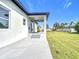 Back of the home featuring a covered patio and green lawn extending to the fenced-in perimeter at 13527 Ainsworth Ln, Port Charlotte, FL 33981