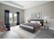 Bright bedroom featuring two windows, hardwood floors, a grey bed frame, and soft decor at 13527 Ainsworth Ln, Port Charlotte, FL 33981