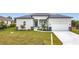 Charming single-story home featuring a neutral color scheme, two-car garage, and a well-manicured lawn at 13527 Ainsworth Ln, Port Charlotte, FL 33981