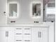 Bright bathroom featuring a dual vanity, quartz countertops, and two illuminated mirrors at 14112 Monserrate Ln, Port Charlotte, FL 33981