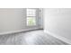 Corner bedroom featuring gray wood floors and an exterior window at 14112 Monserrate Ln, Port Charlotte, FL 33981