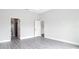 Neutral bedroom with gray wood floors, white trim, and two open doorways at 14112 Monserrate Ln, Port Charlotte, FL 33981