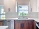 Modern kitchen featuring stainless dishwasher, granite countertops, and wood grain cabinets at 14112 Monserrate Ln, Port Charlotte, FL 33981