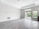 Open living room featuring gray wood floors, sliding glass doors and plenty of natural light at 14112 Monserrate Ln, Port Charlotte, FL 33981