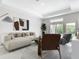 Bright and airy living room featuring modern furnishings, stylish decor, and large windows overlooking the backyard at 14112 Monserrate Ln, Port Charlotte, FL 33981