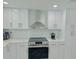 Modern kitchen with white cabinets, stainless steel appliances, and white subway tile at 4229 Floramar Ter, New Port Richey, FL 34652