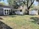 Backyard featuring storage sheds, an oak tree, and grass at 406 E Young St, Plant City, FL 33563
