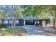 Dark-painted house with a driveway, surrounded by lush green trees at 406 E Young St, Plant City, FL 33563