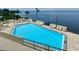 Inviting pool area with ample lounge chairs and stunning water views at 6035 Sea Ranch Dr # 202, Hudson, FL 34667