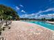 Community pool with lounge chairs and lake view at 13824 Orange Sunset Dr # 202, Tampa, FL 33618