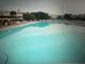 Large community swimming pool with lounge chairs for residents at 2070 World Parkway Blvd # 50, Clearwater, FL 33763