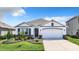 Beautiful single-story home with lush landscaping, a well-manicured lawn and a two-car garage at 17518 Canopy Pl, Bradenton, FL 34211