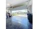 Spacious garage with a sleek epoxy floor and an open door showcasing the home's inviting exterior at 17518 Canopy Pl, Bradenton, FL 34211