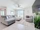 Open-concept living room with a comfortable sectional sofa, ceiling fan, and neutral decor at 17518 Canopy Pl, Bradenton, FL 34211