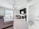Bright living room featuring a ceiling fan, tile floors, and a cozy fireplace at 17518 Canopy Pl, Bradenton, FL 34211