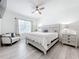 Serene main bedroom featuring light wood floors, a ceiling fan, and large windows at 17518 Canopy Pl, Bradenton, FL 34211