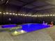 Night view of a screened pool and spa, illuminated by underwater lights and string lights for evening swims at 17518 Canopy Pl, Bradenton, FL 34211