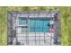 Aerial view of an in-ground pool and hot tub with a screened enclosure and outdoor seating at 17518 Canopy Pl, Bradenton, FL 34211