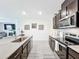 Open kitchen with dark cabinetry, stainless steel appliances, and a large island at 17518 Canopy Pl, Bradenton, FL 34211