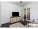 Bright living room with French doors opening to kitchen and flat-screen TV at 2228 Valrico Forest Dr, Valrico, FL 33594