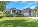 Two-story home with a three-car garage and lush landscaping at 2228 Valrico Forest Dr, Valrico, FL 33594