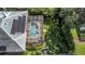 Aerial view showing a home with solar panels, screened pool, and large backyard at 2228 Valrico Forest Dr, Valrico, FL 33594