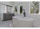 Modern bathroom with a freestanding tub, walk-in shower, and gray vanity at 2228 Valrico Forest Dr, Valrico, FL 33594