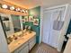 Bright bathroom with teal walls, double vanity, and linen closet at 6009 Sea Ranch Dr # 301, Hudson, FL 34667