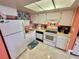 Well-equipped kitchen featuring white cabinets and appliances at 6009 Sea Ranch Dr # 214, Hudson, FL 34667