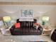 Comfortable living room featuring a brown leather couch and end tables at 6009 Sea Ranch Dr # 214, Hudson, FL 34667