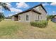 Tan house with covered patio, landscaping, and AC units at 1005 Sonesta Ave, Brandon, FL 33511