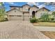 Two-story house with tan exterior, three-car garage, and landscaping at 1005 Sonesta Ave, Brandon, FL 33511