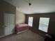 Cozy bedroom with carpeted floor, two windows, and a door providing access and natural light at 10453 Westpark Preserve Blvd, Tampa, FL 33625