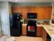 Kitchen boasts wooden cabinetry and modern black appliances at 10453 Westpark Preserve Blvd, Tampa, FL 33625