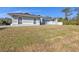 Side view of a light blue house with a large grassy area and mature trees at 18482 Holly Ave, Port Charlotte, FL 33948