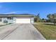 Attached garage with a white door and a long driveway at 18482 Holly Ave, Port Charlotte, FL 33948
