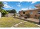 Backyard patio with a dining set and firepit offer an outdoor gathering space, surrounded by green grass and privacy fence at 1801 40Th N St, St Petersburg, FL 33713