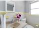 Bathroom featuring vanity, toilet and yellow and white tiling at 1801 40Th N St, St Petersburg, FL 33713