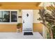 A welcoming front door with decorative features, surrounded by potted plants, and adjacent to a window at 1801 40Th N St, St Petersburg, FL 33713