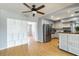 Open kitchen with stainless steel appliances, hardwood floors, a ceiling fan, and light gray walls at 1801 40Th N St, St Petersburg, FL 33713