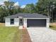 New single-Gathering home with gray garage door at 13435 Kaplan Ter, Port Charlotte, FL 33981