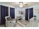 Bedroom featuring crib, armchair, and navy blue curtains at 1801 40Th N St, St Petersburg, FL 33713