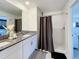 Bathroom with dual sinks, granite counters, white cabinets, and a tiled shower at 12764 Weston Oaks Ln, Riverview, FL 33579