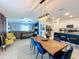 Open-concept dining area with wood table, blue velvet chairs, modern light fixture, and views of the living room and kitchen at 12764 Weston Oaks Ln, Riverview, FL 33579