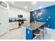Stylish kitchen island with granite countertops, seating, and views of the stainless steel appliances and white cabinets at 12764 Weston Oaks Ln, Riverview, FL 33579