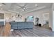 Open living room with gray sectional sofa and wood-look floors at 5735 Shorebird Br, Land O Lakes, FL 34638