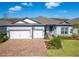 New house exterior with a two-car garage and well-manicured lawn at 5735 Shorebird Br, Land O Lakes, FL 34638