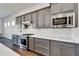 Modern kitchen with gray cabinets, white quartz countertops, and stainless steel appliances at 5735 Shorebird Br, Land O Lakes, FL 34638